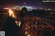 A naked woman standing on a bridge at night.