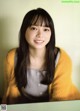 A woman with long black hair and bangs smiles at the camera.