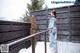 A woman in a blue kimono standing on a wooden deck.