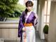 A woman in a purple and white kimono posing for a picture.