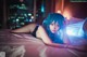 A woman laying on a bed with blue hair.