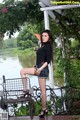 A woman sitting on a bench in front of a lake.